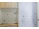 The laundry room features wood floors, white walls, wooden upper cabinets, and washer/dryer hook-ups at 295 N Rural Rd # 128, Chandler, AZ 85226