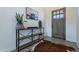 Inviting foyer with wood-look tile floors, stylish console table, and a natural wood front door, blending rustic charm at 4289 W Caribou Ln, Queen Creek, AZ 85142