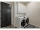 A modern laundry room features a full-size washer and dryer set and white cabinets at 4289 W Caribou Ln, Queen Creek, AZ 85142
