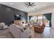 Spacious living room with a gray accent wall, large sliding glass doors, comfortable seating, and hardwood floors at 4289 W Caribou Ln, Queen Creek, AZ 85142