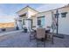Outdoor patio with pavers, umbrella, and round table with seating. The patio is shaded and adjacent to the home's entrance at 4289 W Caribou Ln, Queen Creek, AZ 85142