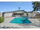 Swimming pool with a slide, surrounded by lush landscaping in the backyard at 4415 W Laurie Ln, Glendale, AZ 85302