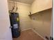 Functional utility room with water heater, shelving, and washing machine hookups at 4621 N 47Th Dr, Phoenix, AZ 85031
