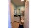 Compact bathroom with a black granite countertop, white cabinet, and ceramic tile flooring at 4845 W Marlette Ave, Glendale, AZ 85301