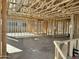 Spacious interior view of wood framing, concrete floors, and open ceiling construction in the unfinished room at 5521 W Paseo Way, Laveen, AZ 85339