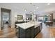 Open-concept kitchen with a large island, farmhouse sink, and pendant lighting, seamlessly connecting to the living and dining areas at 5668 N 206Th N Ln, Buckeye, AZ 85396