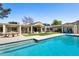 Lush backyard featuring a pool, grass, and a patio with a dining set at 6301 E Exeter Blvd, Scottsdale, AZ 85251