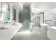 Modern bathroom with dual sinks, glass shower, and soaking tub with marble accent wall at 6301 E Exeter Blvd, Scottsdale, AZ 85251