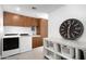 Well-equipped laundry room with front loading washer and dryer and custom wood cabinets at 6301 E Exeter Blvd, Scottsdale, AZ 85251