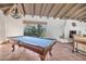 Entertaining game room includes a pool table, fireplace, exposed beam ceiling, and ample natural light at 6701 N Scottsdale Rd # 23, Scottsdale, AZ 85250