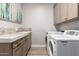 Bright laundry room with front load washer and dryer, granite countertops, and cabinets at 6844 W Mazatzal Dr, Peoria, AZ 85383