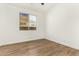 Bright bedroom featuring wood-look flooring, a window, and neutral walls at 7307 E Laguna Azul Ave, Mesa, AZ 85209