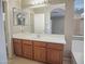 Well-lit bathroom with wood cabinets, white countertops, and a large mirror at 8613 S 49Th Dr, Laveen, AZ 85339