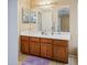 Well-lit bathroom featuring a large mirror over a wooden vanity with ample storage, and tile flooring at 8613 S 49Th Dr, Laveen, AZ 85339