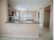 Open kitchen layout with a breakfast bar, tile flooring, and modern appliances at 8613 S 49Th Dr, Laveen, AZ 85339