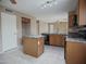 A bright kitchen with a tile floor, an island, a sink, and wood cabinets at 8613 S 49Th Dr, Laveen, AZ 85339