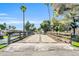 Charming community wooden bridge framed by lush greenery and palm trees under a bright blue sky at 930 S Dobson Rd # 41, Mesa, AZ 85202