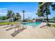 Refreshing community pool with lounge chairs and manicured lawns, surrounded by mature trees and clear skies at 930 S Dobson Rd # 41, Mesa, AZ 85202