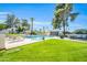 Inviting community pool area with lounge chairs, lush greenery, and shade trees under a clear blue sky at 930 S Dobson Rd # 41, Mesa, AZ 85202