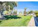 Tranquil community park with a wooden bridge, lush lawn, mature trees, and a serene pond under a clear blue sky at 930 S Dobson Rd # 41, Mesa, AZ 85202