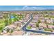 Aerial view of community with lush green landscaping, well-maintained lawns, and a pond at 9426 E Los Lagos Vista Ave, Mesa, AZ 85209