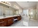 Spacious bathroom features double sinks, soaking tub, glass shower, and marble tile floor at 9426 E Los Lagos Vista Ave, Mesa, AZ 85209
