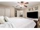 Cozy bedroom features plush bedding, ceiling fan, and TV on dresser at 9426 E Los Lagos Vista Ave, Mesa, AZ 85209