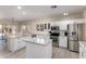 Modern kitchen featuring white cabinets, stainless steel appliances, and a center island with marble countertops at 9426 E Los Lagos Vista Ave, Mesa, AZ 85209