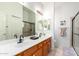 Bright bathroom with double sinks, wood cabinets, and a tiled walk-in shower at 9537 E Flint Dr, Gold Canyon, AZ 85118