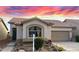 Inviting single-story home with a neutral-toned exterior, well-kept yard and tile roof, under a vibrant sunset sky at 9537 E Flint Dr, Gold Canyon, AZ 85118