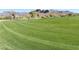 View of a lush, well-maintained green golf course with beautiful mountain views in the background at 9537 E Flint Dr, Gold Canyon, AZ 85118