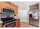 Practical kitchen with wood cabinets, stainless steel appliances, and easy access to both the garage and pantry at 9537 E Flint Dr, Gold Canyon, AZ 85118