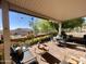 Covered patio with brick flooring and lush landscaping with a peek of the view at 9537 E Flint Dr, Gold Canyon, AZ 85118