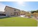 Expansive backyard featuring a pool, synthetic grass, and patio area with a view of the home's exterior at 15934 W Banff Ln, Surprise, AZ 85379