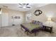 Spacious bedroom with carpet floors, ceiling fan, and modern wall-mounted electric fireplace at 15934 W Banff Ln, Surprise, AZ 85379