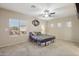 Bright bedroom featuring a ceiling fan and large window at 15934 W Banff Ln, Surprise, AZ 85379