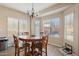 Cozy dining area features a round table with seating for four, a decorative chandelier and natural light from the windows at 15934 W Banff Ln, Surprise, AZ 85379