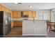 Bright kitchen with granite countertops, stainless steel refrigerator and wood cabinets for storage and food preparation at 15934 W Banff Ln, Surprise, AZ 85379