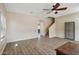 Spacious living room with wood-look floors, a ceiling fan, and stairway entrance at 15934 W Banff Ln, Surprise, AZ 85379