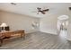 Spacious living room with wood-look flooring, a ceiling fan and large windows for natural light at 15934 W Banff Ln, Surprise, AZ 85379