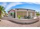 Expansive backyard featuring a curved patio, desert landscaping, comfortable seating, and desert-inspired views at 16464 W Una Noche Ct, Surprise, AZ 85374