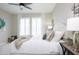 Bright bedroom with a plush bed, neutral tones, white shutters, ceiling fan, and decorative accents at 16464 W Una Noche Ct, Surprise, AZ 85374