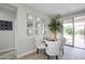 Neutral dining area features a glass table, white upholstered chairs, and a sliding glass door at 16464 W Una Noche Ct, Surprise, AZ 85374