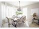 Sunlit dining room featuring a stylish chandelier and a beautifully set table for an intimate gathering at 16464 W Una Noche Ct, Surprise, AZ 85374