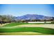 Picturesque golf course view with lush green grass and mountain views at 16464 W Una Noche Ct, Surprise, AZ 85374