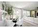 Bright living area with a glass dining table, comfortable white sofa, and sliding glass door at 16464 W Una Noche Ct, Surprise, AZ 85374