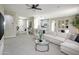 Spacious living room featuring a modern ceiling fan and seamless flow into the kitchen and dining area at 16464 W Una Noche Ct, Surprise, AZ 85374