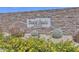 Entrance sign to Desert Oasis at Surprise featuring a stone wall and beautiful landscaping at 17165 W Oberlin Way, Surprise, AZ 85387