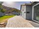 Paver patio leading to backyard with landscaped hill, retaining wall and mountain views at 1723 E Behrend Dr, Phoenix, AZ 85024