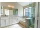 Bright bathroom featuring double sinks, stylish cabinets, and a glass-enclosed shower and tub at 1723 E Behrend Dr, Phoenix, AZ 85024